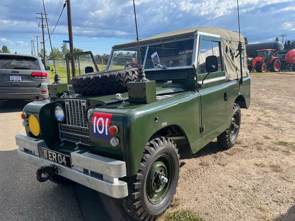 A Land Rover antique military vehicle with radio annentas attached 