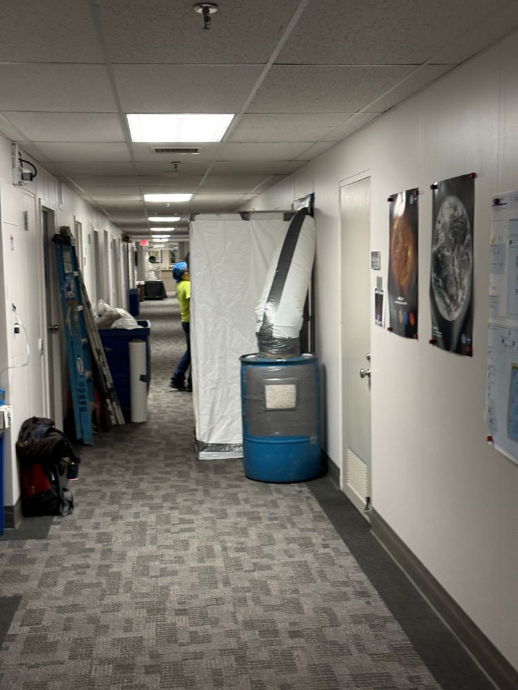 Office building hallway with work equipment to remediate asbestos set up in front of an office 