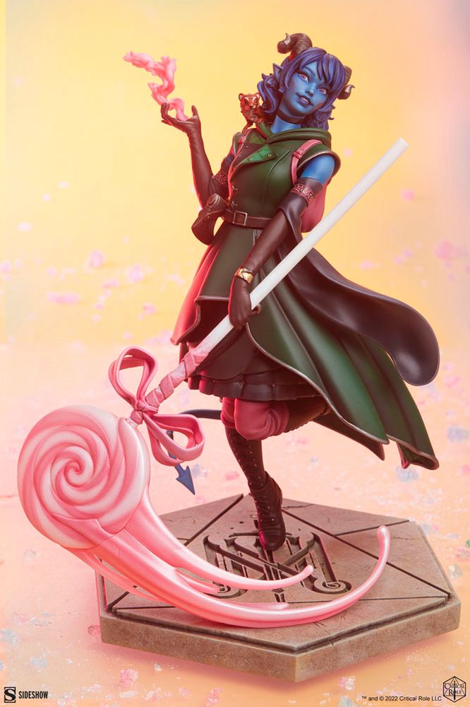 Official merch product from Critical Role. A statuette (some might call it a figure) of Laura Bailey’s Series 2 character, Jester Lavorre. A blue teifling girl, a skilled cleric of a trickster god, whose Spiritual Weapon of choice became a giant pink lollipop. (Serrated Edges Optional)