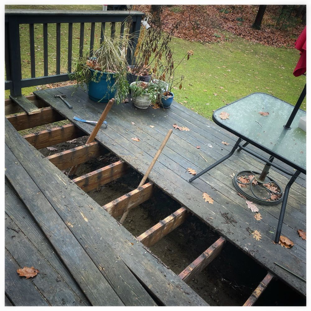 A deck with boards taken up and tools scattered around.