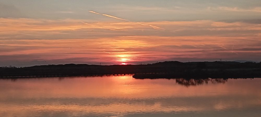 A picture of the setting sun, with the waters spanning far and wide