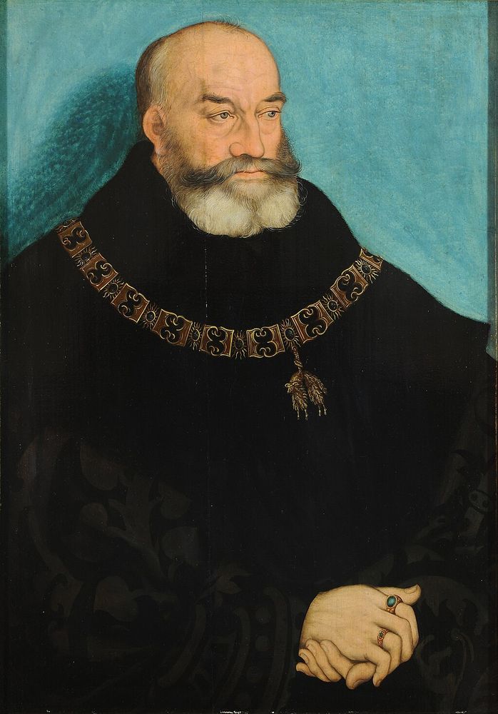 Portrait of George the Bearded, Duke of Saxony by Lucas Cranach the Elder, c. 1534 (Museum der bildenden Künste). In the portrait, a balding and bearded man dressed in a voluminous robe of all black; he is presented in a 3/4 pose. The man's hands are clasped and he wears a two rings. Around his neck is the collar of the Order of the Golden Fleece.  The backround is aqua with some behind the figure's head. 