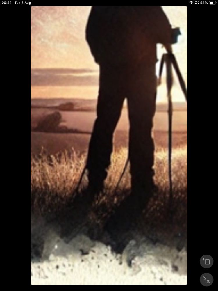 The silhouette of a man with a photography tripod. The tripod’s left leg duplicates so that it emerges beside both his left and right leg (logically, following the line down from the top, it should only emerge behind his right foot)  