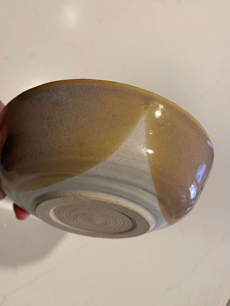 bottom of a homemade bowl, glazed white with tan dips