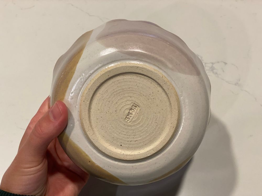 bottom of a homemade bowl, my initials carved into the bottom, glazed white with purple and tan dips