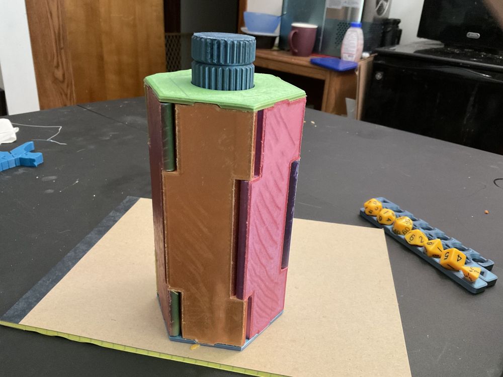 3D Printed dice box, closed up. In background: dice trays with dice on them.