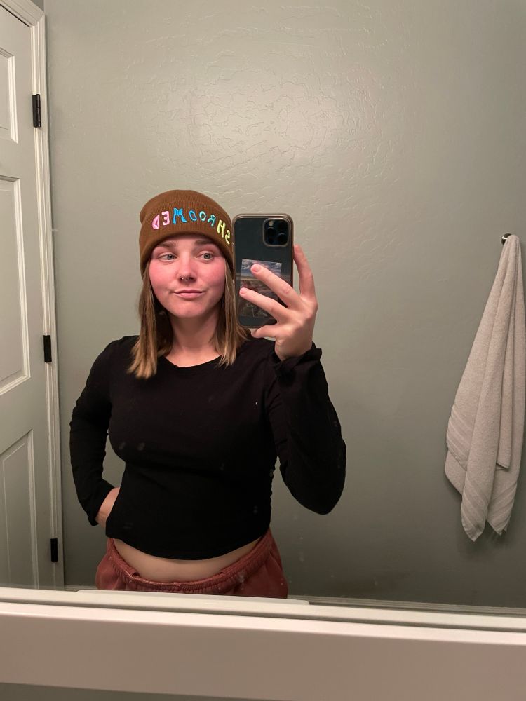 me taking a mirror selfie in a black long sleeve shirt and brown beanie 