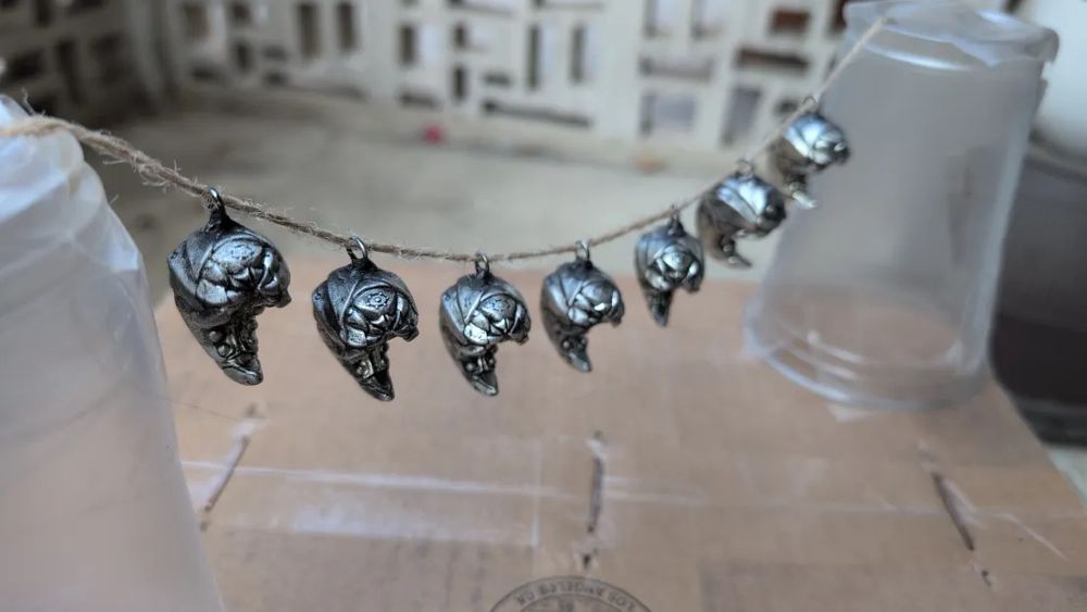 photo of pewter pendants of biomech grubs (front) 