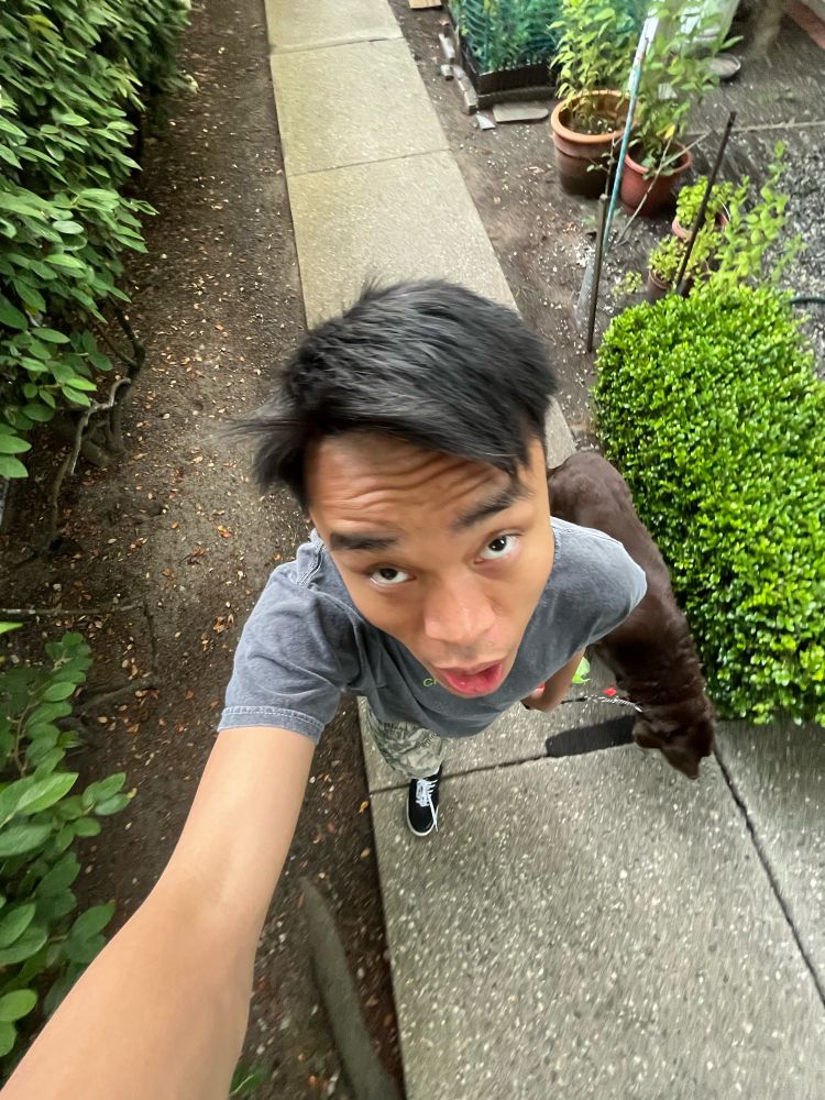 .5 photo of Brandon walking his dog while wearing black and white shoes as well as a cropped Charli XCX tee