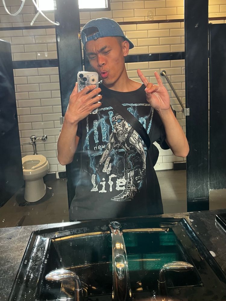 Brandon doing a “too sweet” finger pose in a vintage NWO graphic tee with Hulk Hogan flexing