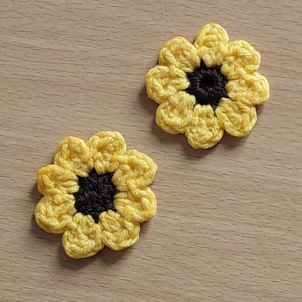 Crochet sunflower magnets using acrylic yarn and fabric glue. Colours used are yellow and dark brown.