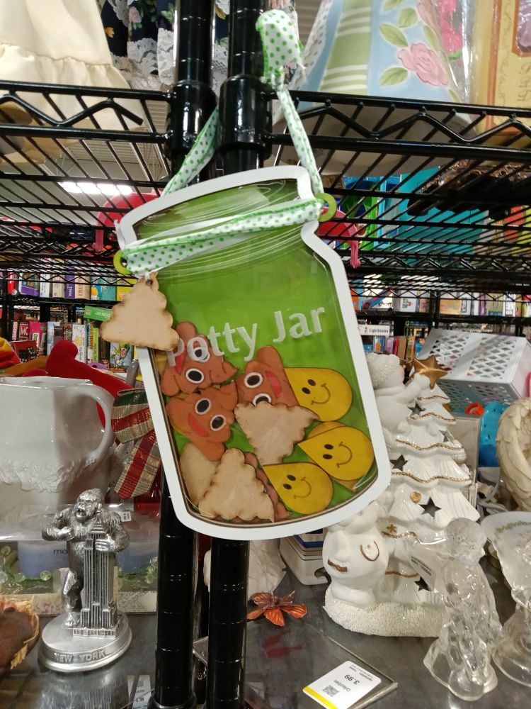 A wall hanging of a "potty jar" with poop-and pee-shaped tokens inside