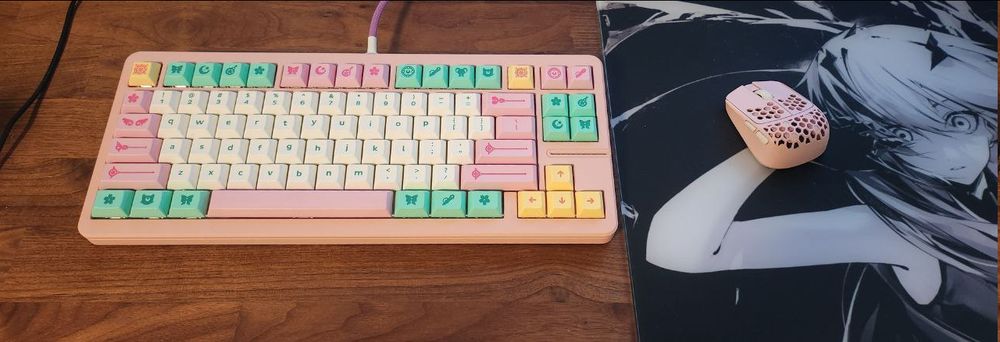 A desk with a computer keyboard (Wooting 80HE in a pink GT-80 case with DSA Magic Girl keycaps) beside a computer mouse (G-Wolves HSK 4k pro mouse) on a mousepad (Wallhack SP-004 frenzy sora).