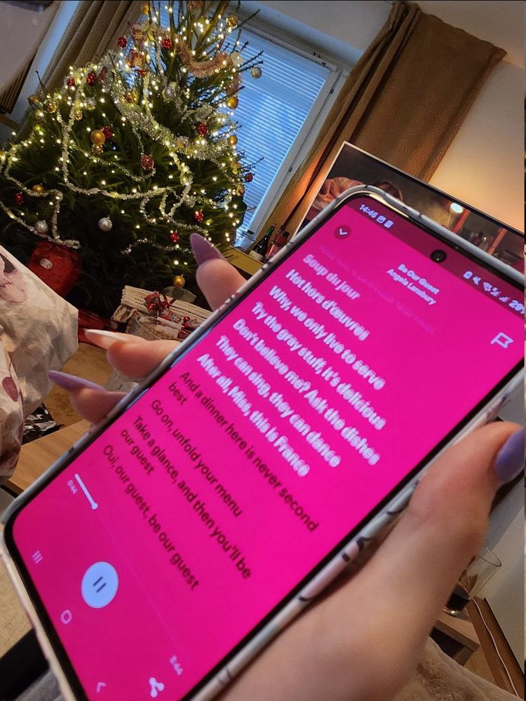 gay hands holding a phone showing spotify lyrics
