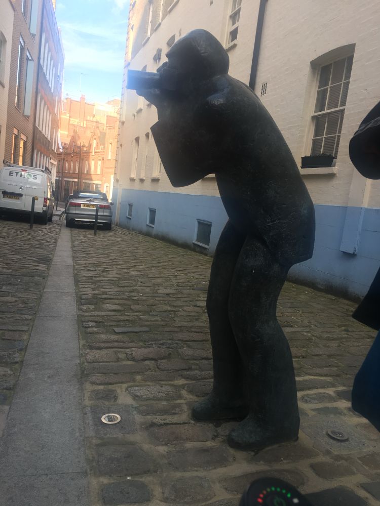 A statue of a man taking a photograph