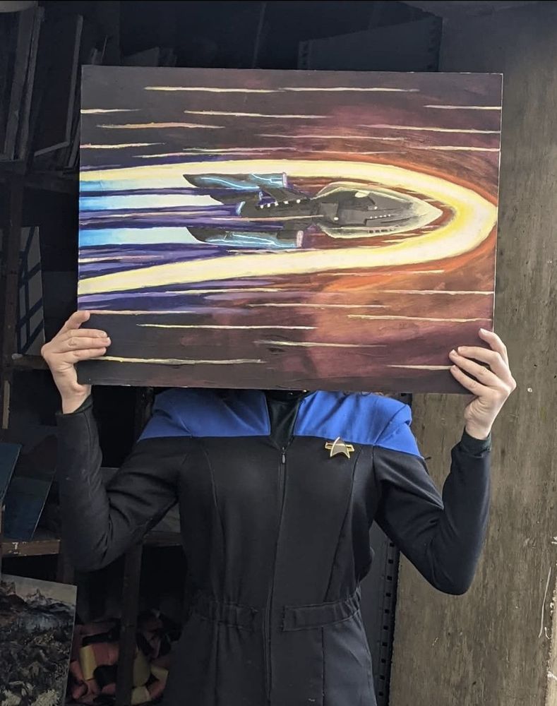 Meg holding a painting in Uniform 