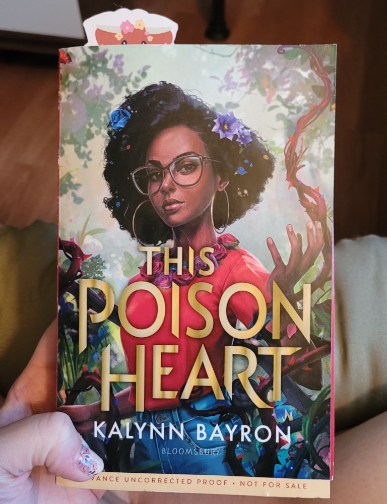 Someone holding the book This Poison Heart by Kalynn Bayron. 