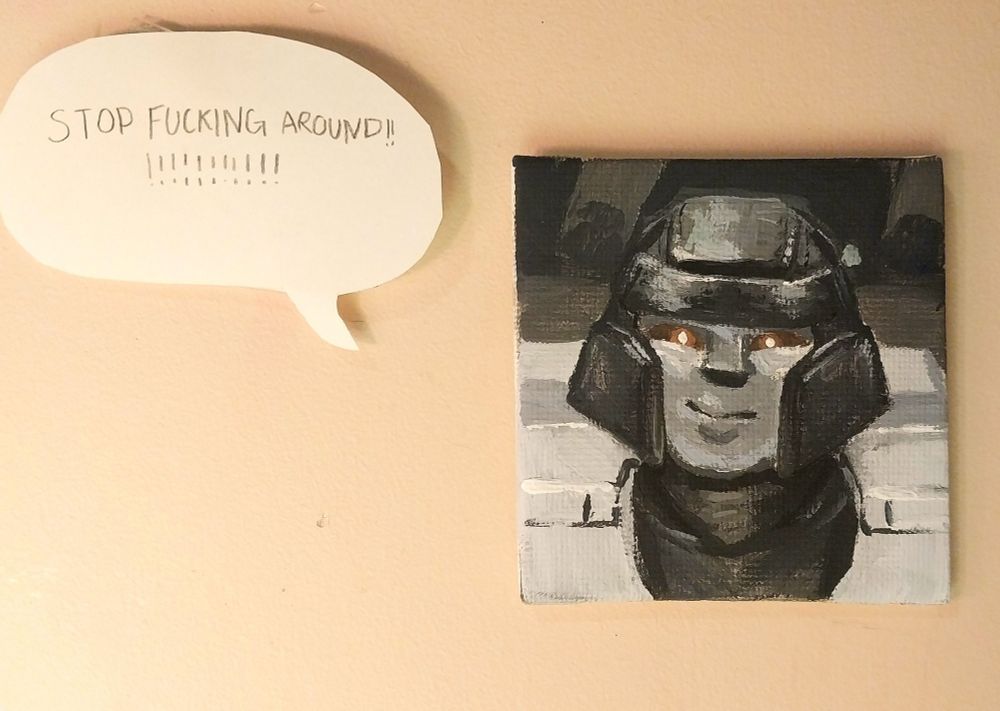 a tiny acrylic painting of D-16 from transformers one. He looks like a goober, smiling and shit. tf he so happy for??? There is a speech bubble next to him that says "STOP FUCKING AROUND!!!!!!!!!!!" as he is a motivational piece for my wall.