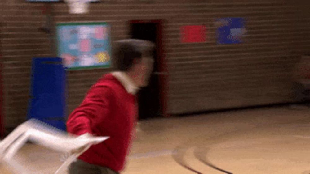 a man in a red sweater is holding a piece of paper in his hand