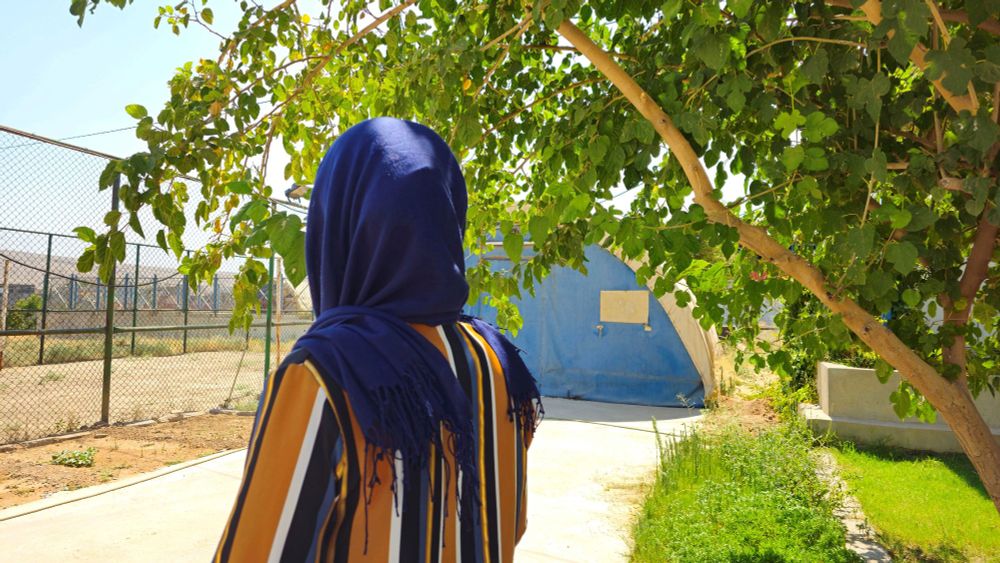 Adana (24) ist Jesidin. Sie lebt in einem Camp für Vertriebene im Nordirak. Auf dem Bild steht sie mit dem Rücken zur Kamera. Foto: Sarah Easter/CARE