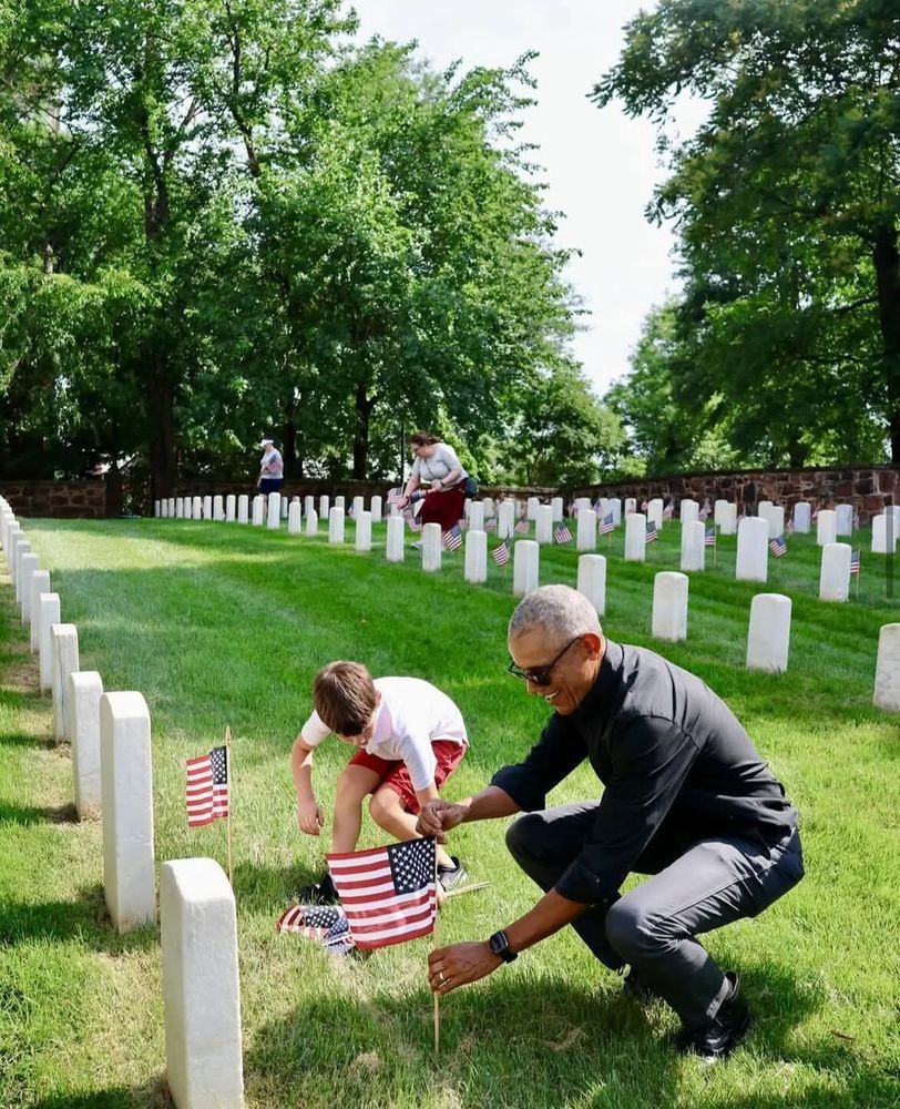 President Obama placing US flags on veteran's grave.