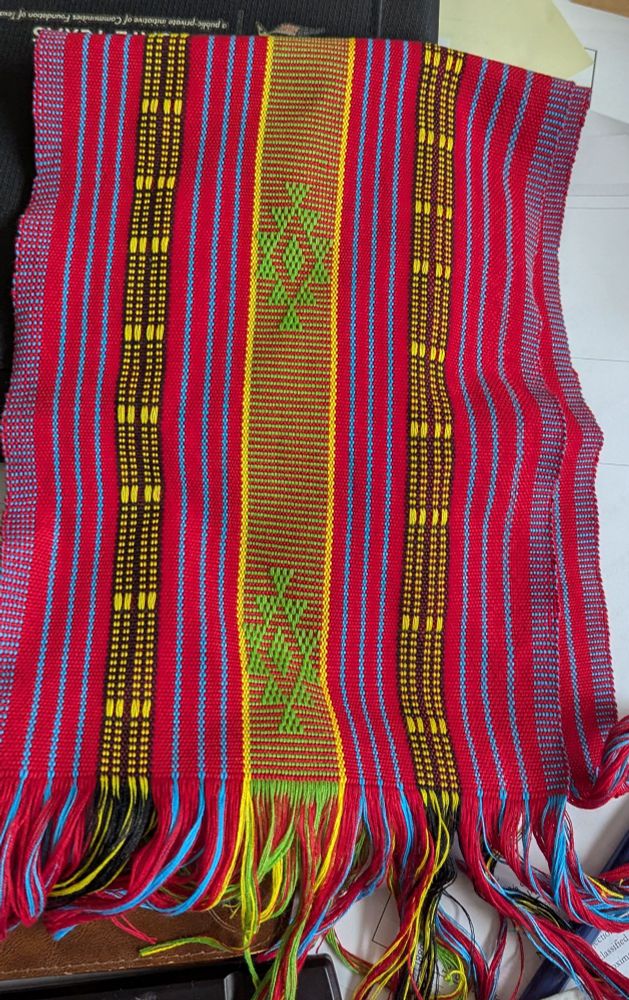 Hand-woven scarf from Timor-Leste. Bright stripes with a pattern in the center.