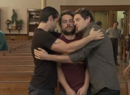 It’s Always Sunny in Philadelphia scene with Mac and Dennis hugging Charlie in the middle in front rows of pews in a church