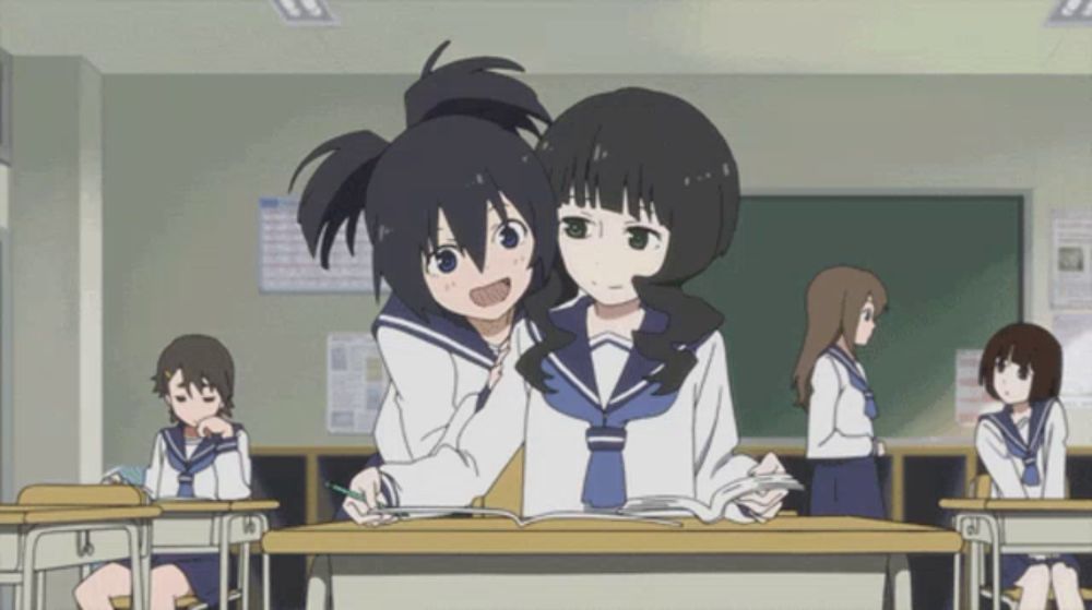 two anime girls are sitting at desks in a classroom with other students