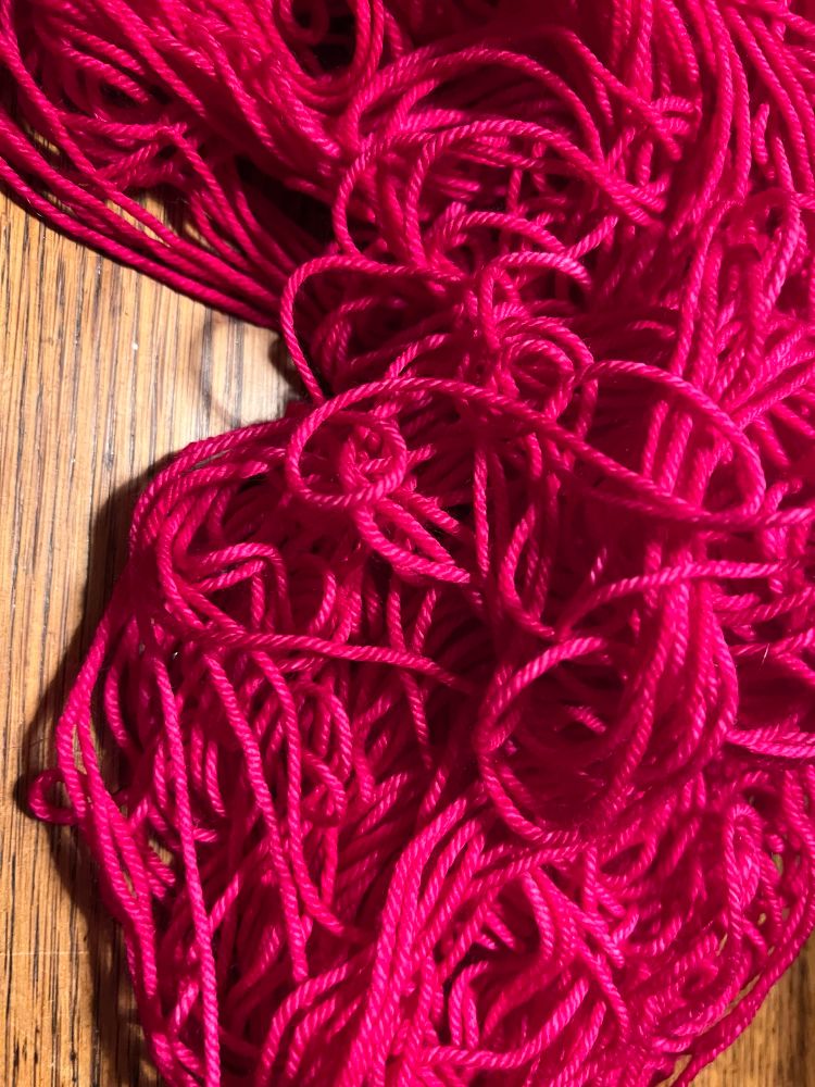 A very tangled pile of beautiful fuschia wool