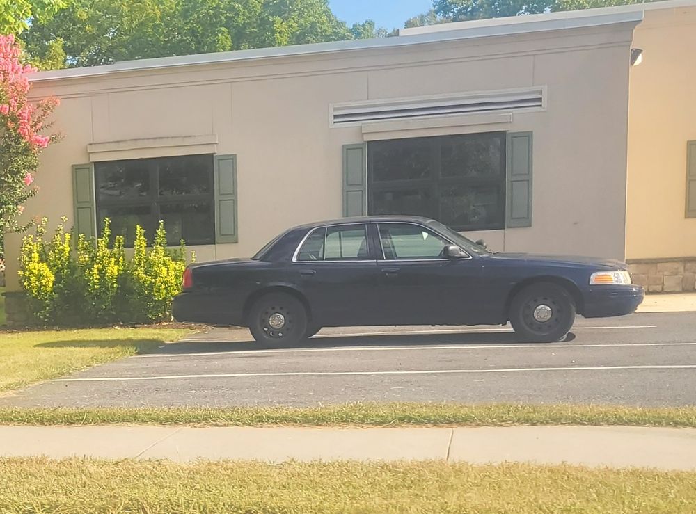 Dark blue crown victoria sitting in front of a Central PA police station 