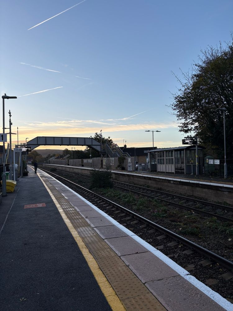 Photo of Stonehouse station with a clear blue sky and a fairly empty platform 