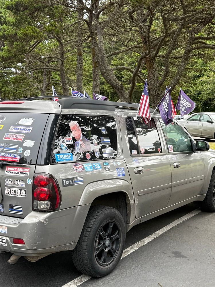A moronic looking vehicle that has Trump stickers and campaign flags all over it. That includes a very large (window size) color picture of the top half of his body. Ish. 