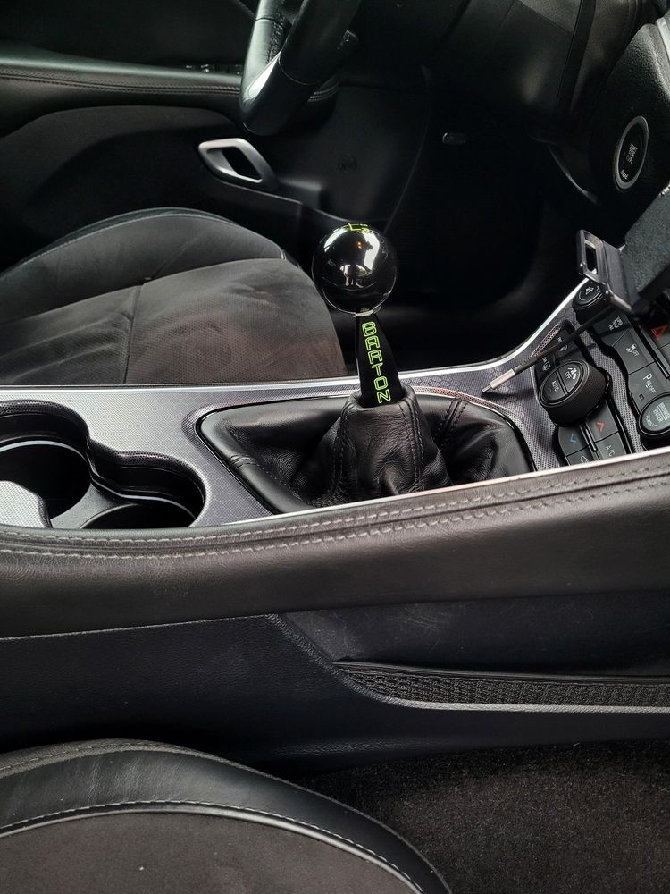 Passenger seat view of a newly installed Barton shifter assembly with flat stick and matching ball. BARTON is engraved on the stick in Sublime green to match the car.