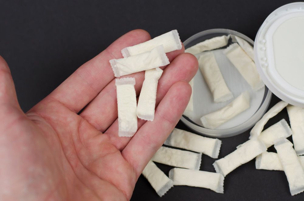 A hand holding several nicotine pouches.