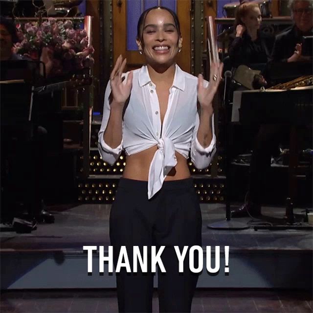 a woman in a white shirt and black pants is giving a thank you