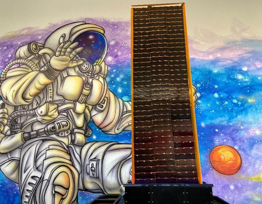 Verkleinerter Prototyp einer im Weltraum hergestellten Solaranlage. (Bild: DCUBED / Solestial)
Im Hintergrund ein Wand-Graffity mit einem vor dem Sternenhintergrund freischwebenden Raumfahrer im Raumanzug.