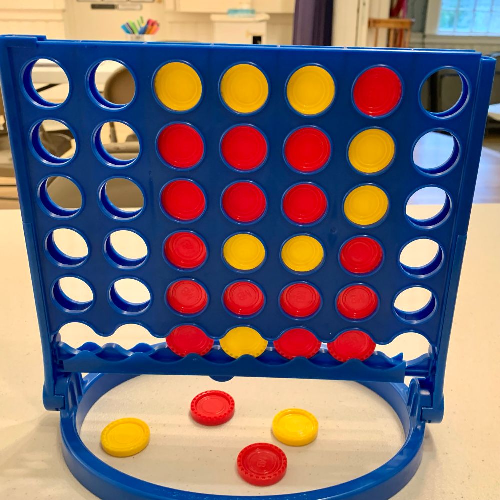 Connect Four game with red and yellow circle pieces forming a question mark.