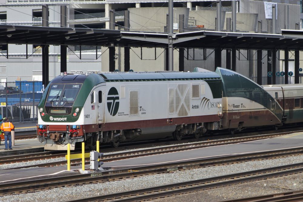A white locomotive with green and brown trim in front of a very short train car that's supposed to "transition" from the height of the locomotive to the much shorter height of the passenger cars. The transition starts out too high regardless.