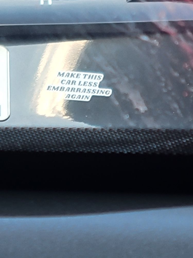 Sticker on a Tesla: "Make this car less embarrassing again"