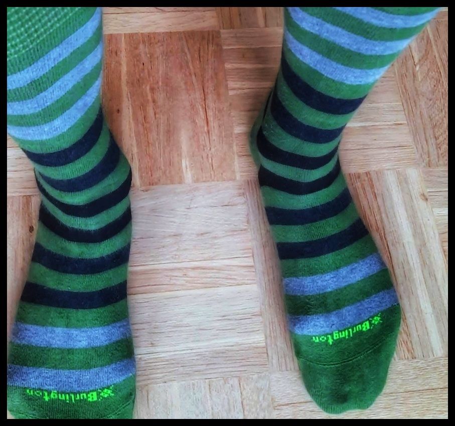 Zwei Füße, bekleidet mit bunten Ringelsocken. 