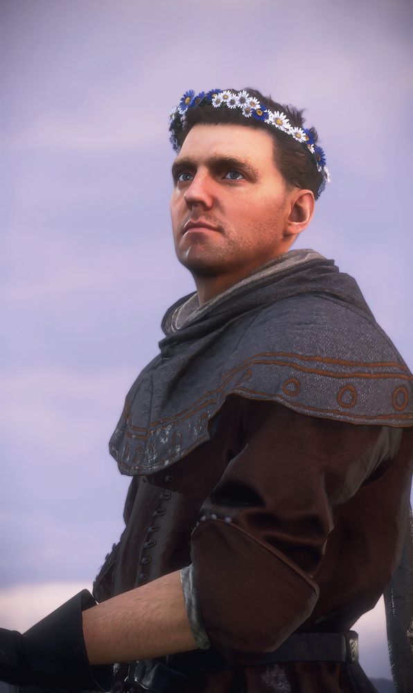 A screenshot of Henry of Skalitz from Kingdom Come Deliverance 2. He is a brown haired man wearing a flower crown
