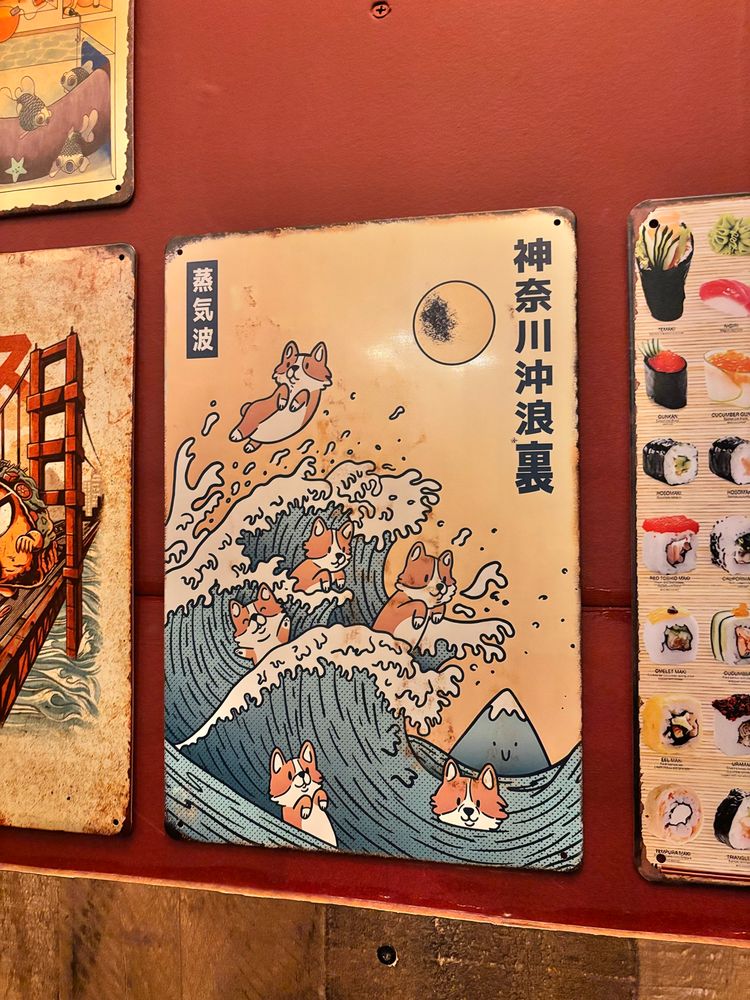 Corgi dogs riding a wave imitating Honkusai’s Great Wave picture. 