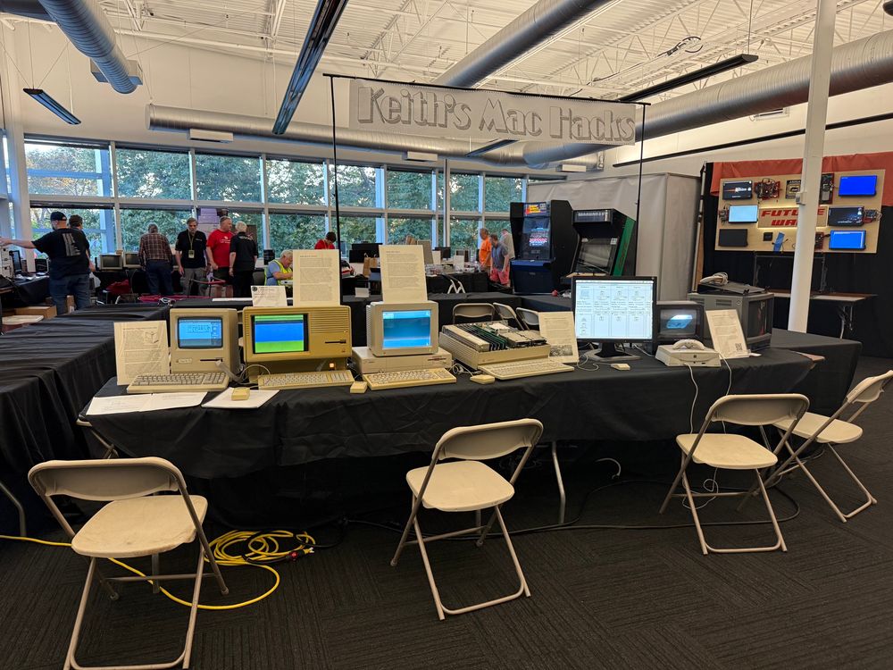 A table at the Computer History Museum in Mountain View, CA with a banner hung above that reads “Keith’s Mac Hacks,” featuring a Twiggy Mac Plus, Lisa 2/10, Amiga 1000, Macintosh II, and two Bandai Pippin AtMarks.