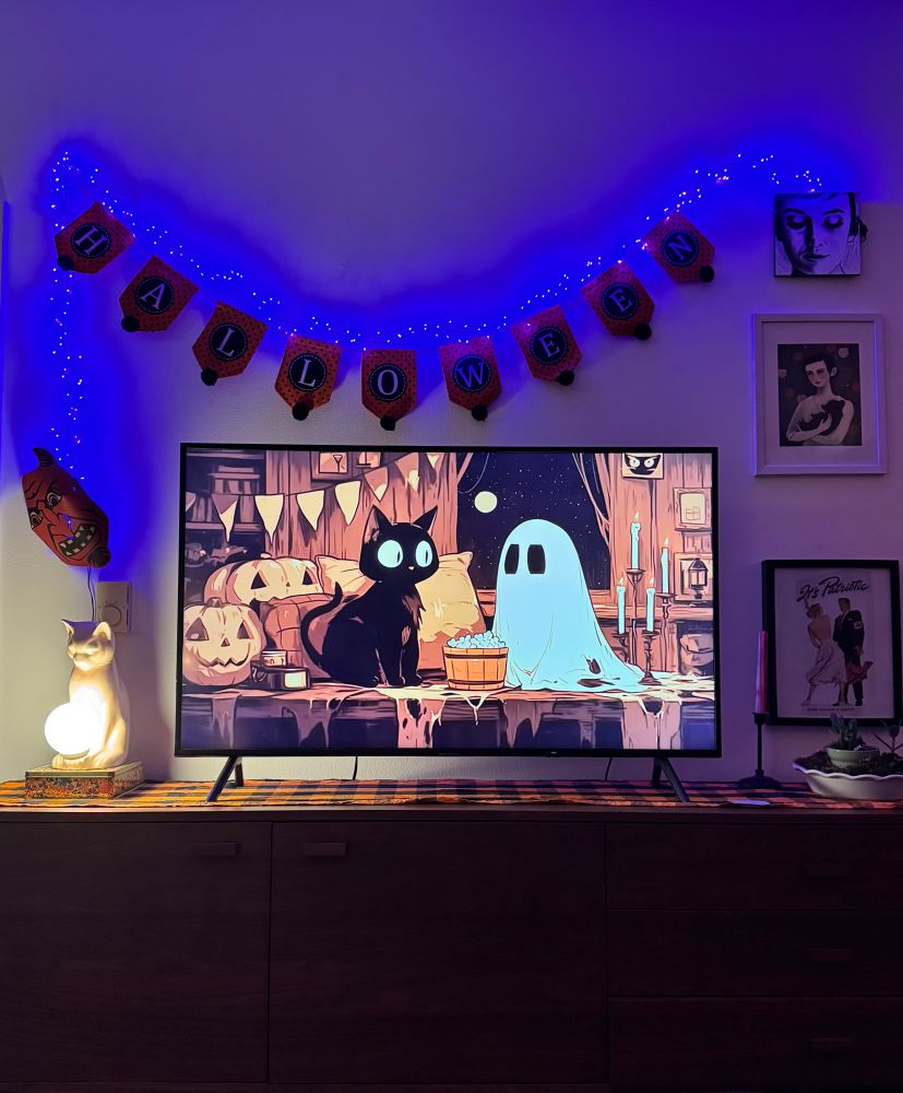 Halloween decorations with purple lights, cats, and ghosts 