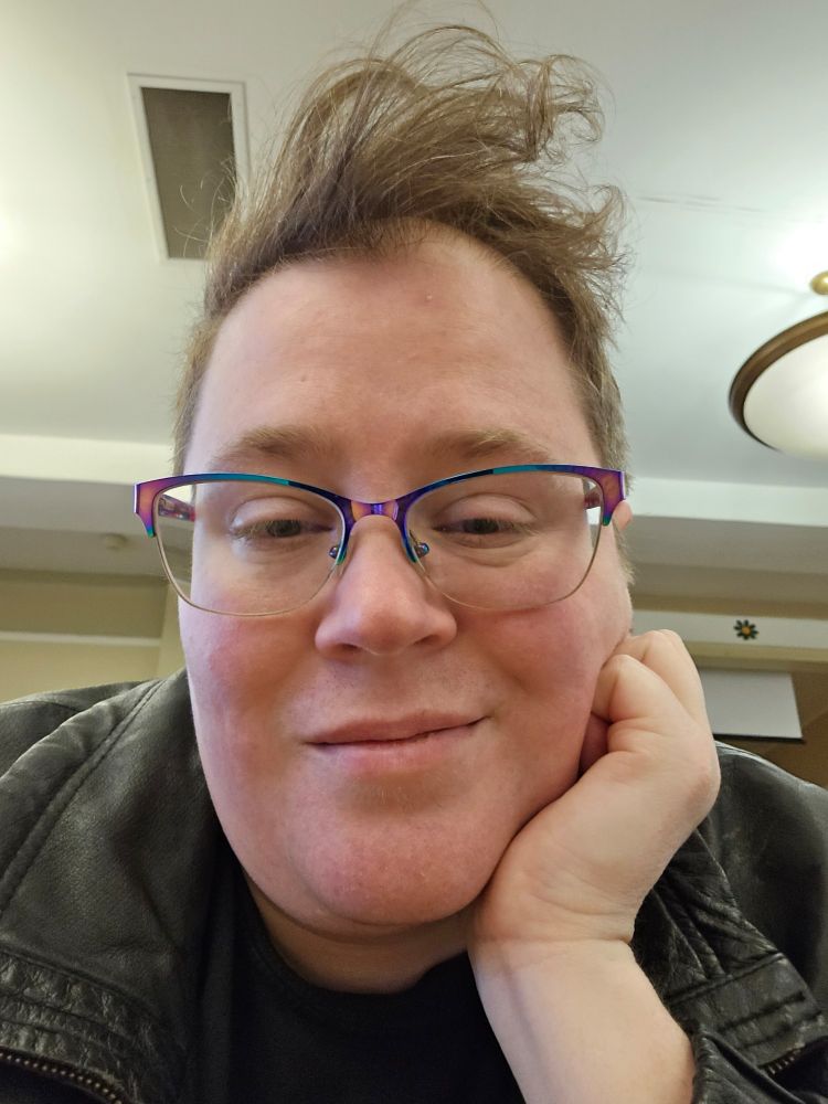 A selfie of me resting my chin on one hand while my hair sticks almost straight up in blatant defiance of gravity despite all my effort to tame it. (Honestly, it's pretty cute. XD)