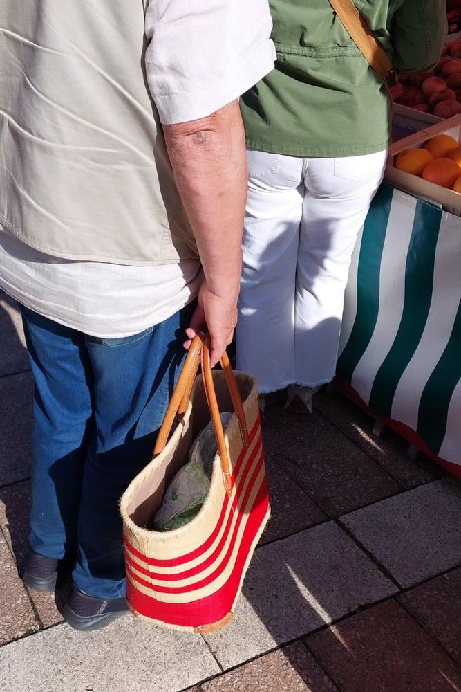 Un homme tenant un panier rayé rouge.