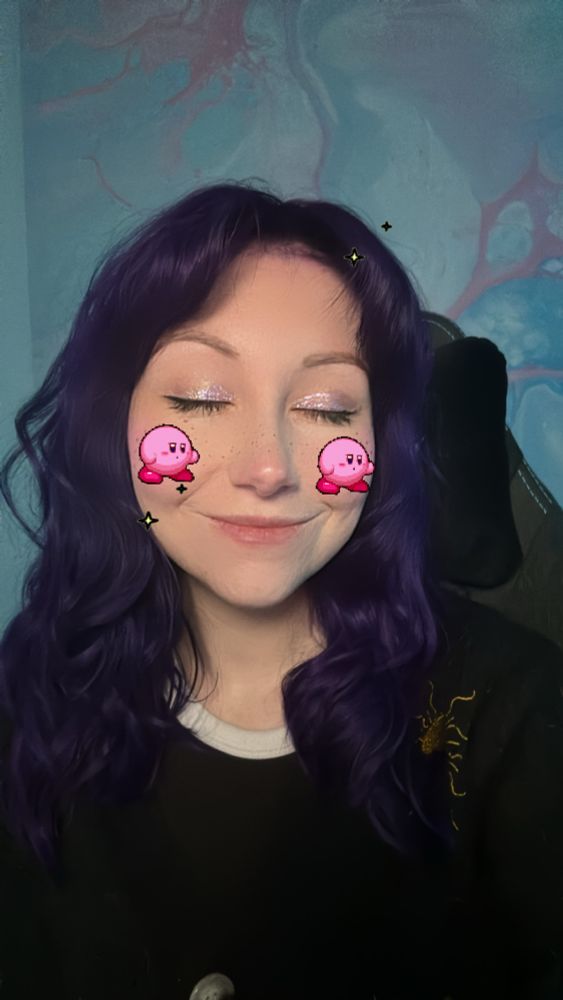 Selfie of Mollie with a filter on that adds little Kirby’s to her cheeks.