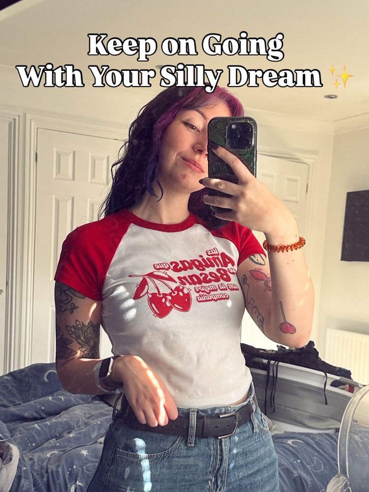 Mirror selfie of mollie. She is wearing jeans and a red and white shirt. There is text at the top that reads “Keep on going with your silly dream”