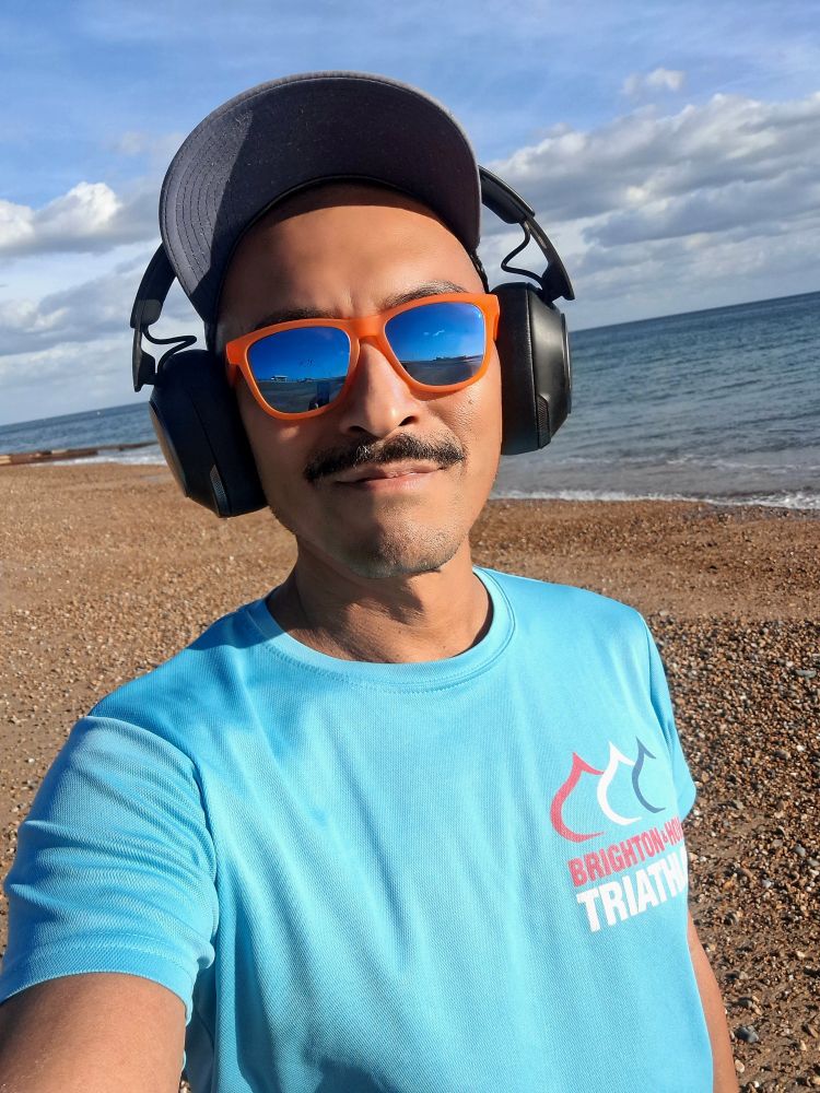 Selfie on Hove Beach with the sea in the background taken at sunset. 
I'm wearing orange rimmed sunglasses 