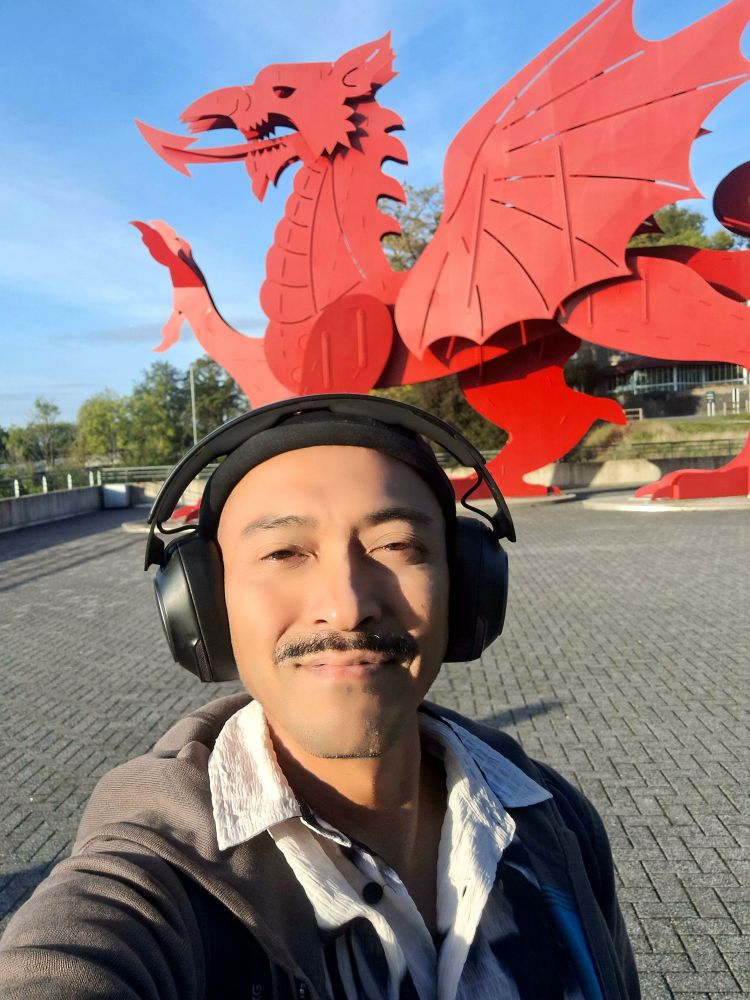 Selfie with a sculpture of a massive red Welsh dragon behind me 